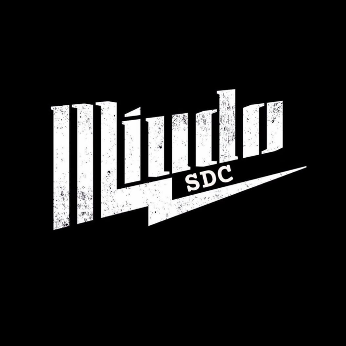 La imagen muestra un logotipo con un diseño gráfico que parece inspirado en el estilo de los años 80 o el arte urbano. El nombre "Miudo SDC" se presenta en una tipografía angulosa y estilizada que crea un efecto de perspectiva, con las letras en blanco y desgastadas, lo que les da una textura y un aspecto de haber sido vivido o expuesto a los elementos.  El uso de las letras en blanco sobre un fondo negro crea un fuerte contraste, haciendo que el logotipo sea llamativo y fácil de reconocer desde la distancia. La abreviatura "SDC" podría referirse a las iniciales del establecimiento o a una frase significativa relacionada con el lugar.  El diseño del logotipo evoca una sensación de modernidad y juventud, y podría ser adecuado para un bar, un club nocturno, una sala de conciertos o cualquier establecimiento relacionado con la música y la cultura juvenil. El estilo es suficientemente versátil como para ser utilizado en una variedad de contextos de marketing y marca, desde la señalización exterior hasta el material promocional en línea.