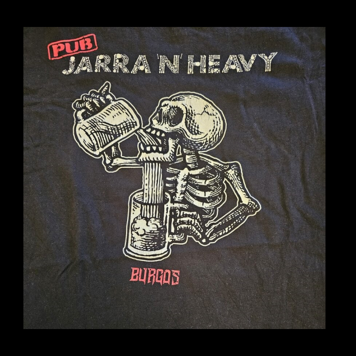 Arriba de la imagen hay escrito "pub" con tipografía sans enmarcado y de rojo, debajo hay escrito con un lettering con trozos de huesos "jarra 'n' heavy" en blanco grisaceo. Bajando hay un esqueleto del mismo color que las letras anteriores bebiendo cerveza con una jarra y la cerveza se cae por su mandibula y llena una jarra. bajando hay escrito con letras metaleras "Burgos"